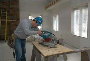 Job superintendent Ron Bailey works on the trim for an addition Willson Builders is putting on the Sujkowski Funeral Home.