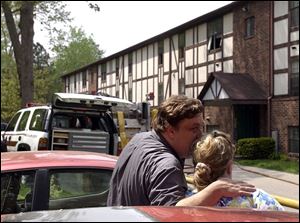 Alex Mak consoles his wife, Carolyne, outside their apartment on West Laskey Road after a fire broke out there yesterday. The blaze was blamed on an overloaded extension cord.