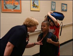 Principal Pamela Van Mooy of Fostoria's Field Elementary School talks with Divante McBeth as he leaves school for the day.
