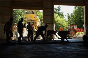CTY BARN19P 1 6/19/04 PHOTO BY LORI KING Ironworkers  pour the floor for a  pole barn being built for injured ironworker Roger Henneman at his Rialto Rd. home.