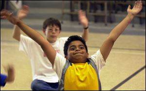 ROV commonspace02p 02 - 07/02/04- Nine-year-old Kiran Venkat, of Perrysburg, streches his arms and his face while preparing for a dance lesson at a creativity camp at Common Space Center for Creativity in Toledo Friday afternoon.  The camp included various painting, ceramic, and dance techniques and ended the week with an exhibition of work and preformance for parents.