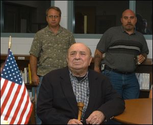Bernard Nusbaum, front, listens to graduation exercises in the company of his sons, Tim and Marty, rear from left.