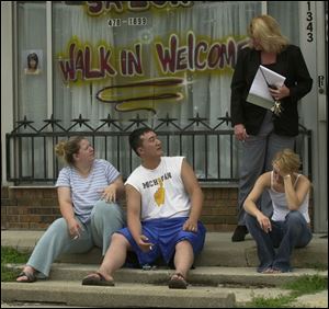 A police detective interviews witnesses to a slaying and suicide outside Payless Construction Inc. on Sylvania Avenue.