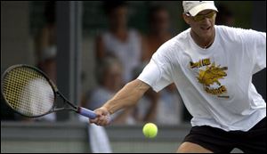 Defending city singles champ Todd Dominiak hits a forehand against Shaul Aloni yesterday at the Toledo Tennis Club.