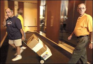 Tavern owners Chuck Cassis, left, and John Brown haul petitions with 16,038 signatures to Government Center for verification in their bid to amend the city of Toledo's smoking ban.
