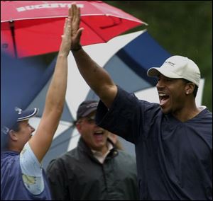 Pro Isabelle Beisiegel high-fives Jim Jackson after the basketball star aced the 160-yard second hole at Highland Meadows yesterday. Jackson has been playing golf for six or seven years.