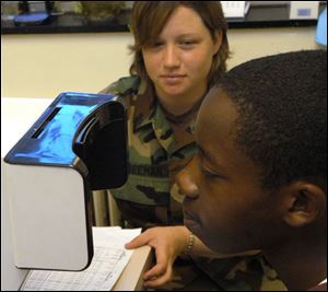 Limon Sanders gets an eye examination from Guardsman Gwen Freeman of Columbus.
