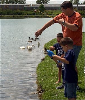 Nbr  friend07p  Friendship Park, Cummings Rd.,  Landon Zura 5 (background), father Craig Zura and  brother Reid 4 (with rod), were also fishing.  The group had caught 5 small fish at this point and released them all to grow bigger. .  Diane Hires  8/7/04