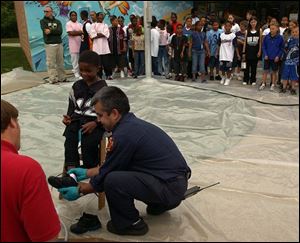 Emergency personnel remove a boy's shoes after testing him for mercury at the Aurora Gonzalez Center.