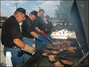 Wood County Sheriff John W. Kohl grills steaks with help from his lieutenants, Jay Harden, Rick Luman, and Stu Stockrider, from left. Sheriff Kohl offered to provide lunch for the emergency personnel gathered for the meeting on his home turf.