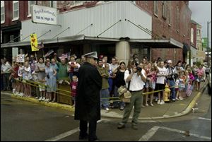 Spectators line the streets of Columbus Grove, Ohio, waiting for the bus carrying the President yesterday. The President made stops in Lima, Ohio, as well as Perrysburg.