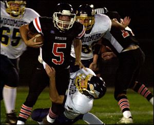 Otsego quarterback Matt Mills is brought down by Woodmore's Derek Speaker in last night's game.