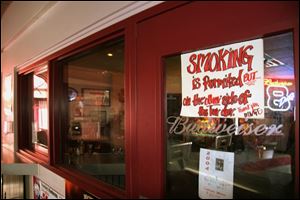 A sign on the window at Myler's Rock Garden advises patrons that they can smoke in the bar, but in a designated area.