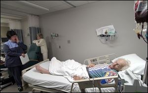 Bernie Rabin, a retired Bowling Green State University professor with leukemia, receives a blood transfusion in Wood County Hospital. His daughter, Cheryl Rabin Plotkin, left, and his wife, Anne, react emotionally as he discusses his prognosis.