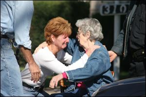 Tina Wilson, left, seeks comfort from her aunt, Jo Fleming, after Ms. Wilson discovered the bodies of her parents, Marlowe and Bertha Wagner, in their Fostoria home. Police say the deaths were a murder-suicide.