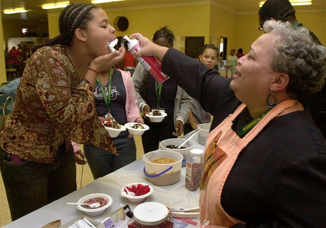 CTY SUNDAE11P 10/11/04 PHOTO BY LORI KING Robinson Jr. Hi 7th grader Moranda Smith gets rewarded for her satisfactory report with a mouth full of whip cream, courtesy of teacher Linda Watson, during sundae treats for all students who received S reports.