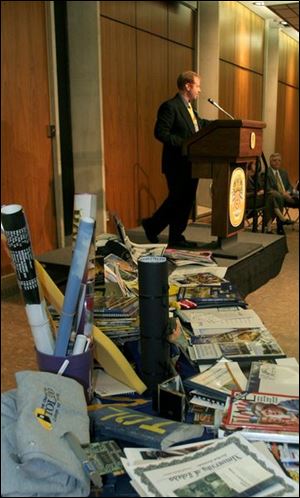 Student Justin Rudisille discusses the con-tents, in the foreground, of a time cap-
sule that'll be buried on the UT campus.