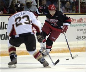 Toledo right wing Tyler Knight takes the puck up ice against Wheeling's Alex Rouleau during the first period last night.