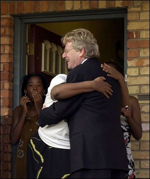 A surprised Winthrop Street resident gives Jerry Springer a big hug when the celebrity shows up unannounced at her door.