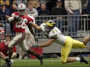 Ohio State cornerback Ashton Youboty eludes Michigan's Tyler Ecker after intercepting a pass.