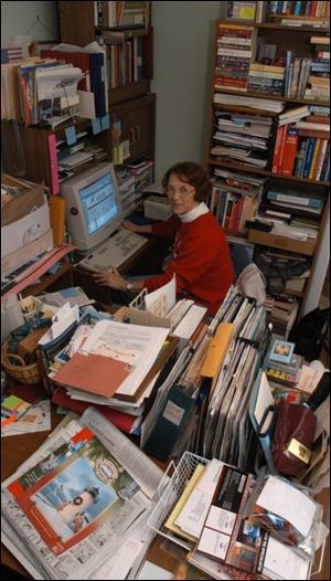 Sharrone Clay in her office, surrounded by books, files, and boxes.