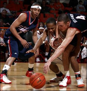 Bowling Green's Perrick Robinson, middle, fights for a loose ball with UIC's Jovan Stefanov (4).