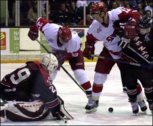 Toledo's Noah Whyte (12) holds off Trenton's Steve Cygan in an attempt to clear room for teammate Reggie Savage (33) in front of goaltender Andrew Allen. The Storm led 2-1 in the first period.