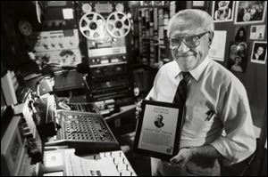 Chester Zablocki, in his studio, displays a plaque honoring his induction into the International Polka Association's Polka Hall of Fame in Chicago in 1994.