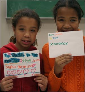 Jacqueline Bonivel, left, and Jasmine Bonivel made their Christmas cards for their dad, Timothy Bonivel, a warrant officer, at a gathering for families of the U.S. Army Reserve's 983rd Engineer Battalion.