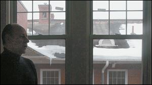 Monclova Historical Foundation president Bill Strayer discusses the improvements that need to be made to the roof seen through the window. It is leaking, and repairs could be pricey.