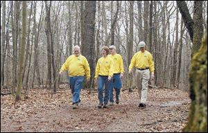 Trail patrol volunteers, from left, Chuck Quinn of West Toledo, Sue Wilson of Toledo, John Flahie of Sylvania, and Jack Mayer of Toledo walk one of the trails in Wildwood Preserve Metropark. The volunteer program is growing.