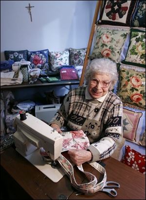 Sister Helen Foos in her sewing room at the St. Ursula Academy Convent. She has made pillows, tote bags, and other items to sell at parish benefits.