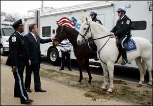 Secretary of Homeland Security Tom Ridge conducts an inspection of security preparations for the presidential inauguration on Jan. 20 and gives one of them a secretarial pat.