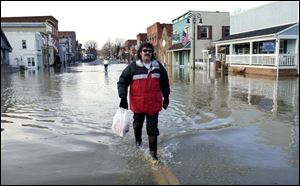 Grand Rapids resident Doug Grey doesn't let a flooded Front Street prevent him from running errands in downtown Grand Rapids. The Maumee River broke over its banks because of the heavy rains and melting snow throughout the region.

