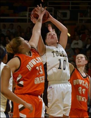 Bowling Green's Liz Honegger attempts to block a show by Toledo's Danielle Bishop as Megan Thorburn watches in last night's game at Savage Hall. Honegger scored 19 for the Falcons. Bushop tallied 17 for the Rockets.