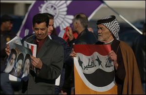 Abas Al-Gazali, left, and his 75-year-old father, Musa, campaign outside the Southgate, Mich., polls for Iraqi expatriates.