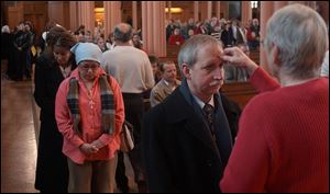 CTY ash09p Toledoan John Madigan receives ashes from St. Francis de Sales church member Joann Zimmel during Ash Wednesday, Feb. 9, 2005. The Blade/Lori King