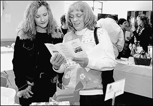 Judi Reese, left, and Debby Sheets look over silent auction items at  The Chocolate Affair  in Sylvania.

