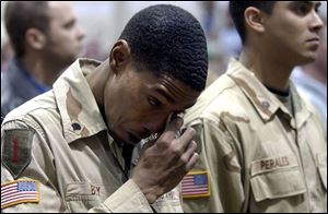 Spec. Joshua Bey of the 216th Engineer Battalion wipes away tears while  Amazing Grace  is played in honor of three fallen comrades. The soldiers were welcomed home yesterday.
