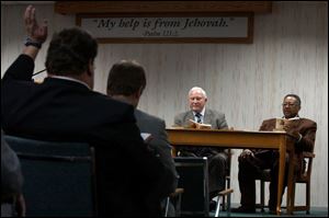A member of the Jehovah's Witnesses North Congregation asks questions of reader George Segur and conductor John Coates during a recent Bible study.