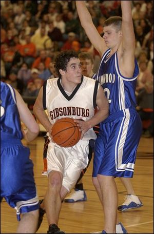 Gibsonburg s Marcus Ahle drives by Elmwood s Dustin Reynolds
for two of his 15 points. Reynolds scored 12 points.
