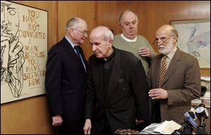 Father Gerald Robinson, center, is surrounded by attorneys,
from left, John Callahan, Henry Herschel, and Alan Konop,
after a press conference yesterday in Mr. Konop s offi ce.
