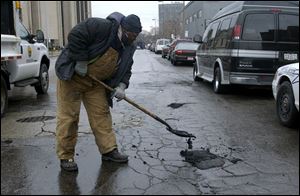 Potholes are fixed on Spielbusch Avenue in downtown Toledo. Major paving work is planned elsewhere this spring.
