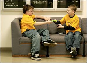 NBR dip05 01 - L-R, Jonathan Boesger and Skylar Sommers, both 11, and from Fayette, share a gameboy as they kill some time inbetween competitions at the Destination Imagination contest at the University of Toledo. The Blade/Allan Detrich