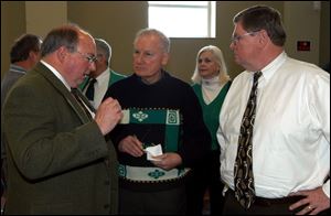Tom Uhler, left, former Toledo Mayor Carty Finkbeiner, and Charlie Chambers chat at yesterday's Jiggs Dinner, held by the Democratic Party at Holy Trinity Greek Orthodox Cathedral.
