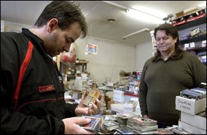 Storm coach Nick Vitucci, left, looks for new additions to his hockey card collection at The Bullpen, with owner Bob Griffin.
