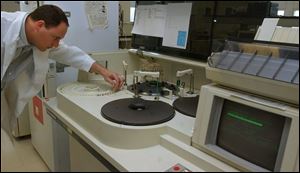 Jason Burns, a toxicologist lab technician with the Lucas County coroner's office, conducts drug tests in the new laboratory, which will cost more than $200,000 a year to operate.