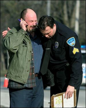 Oregon police Sgt. Ken Reno comforts Wayne Appenfelder, whose great-nephew Dameatrius
McCreary, 5, was struck and killed by a car as he exited a school bus on Starr Avenue.
