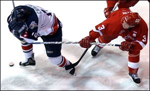 Dayton's Scott Cameron, left, covers up after getting hit in the face by Toledo's Joey Martin at the Sports Arena. 