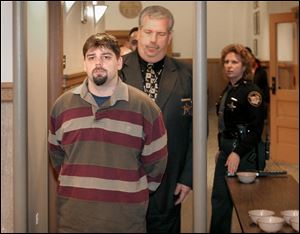 An Ottawa County sheriff's deputy escorts Brian J. Woody, left, out of court after he was sentenced earlier this month.